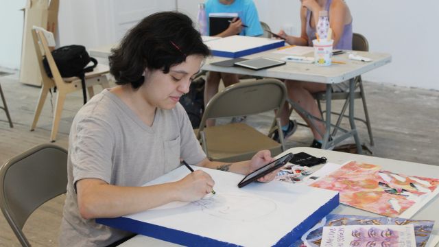 The Way We See Ourselves Gallery Team works with April Sunami. Photo by Sandra Okot-Kotber. The Way We See Ourselves Gallery Team April Sunami